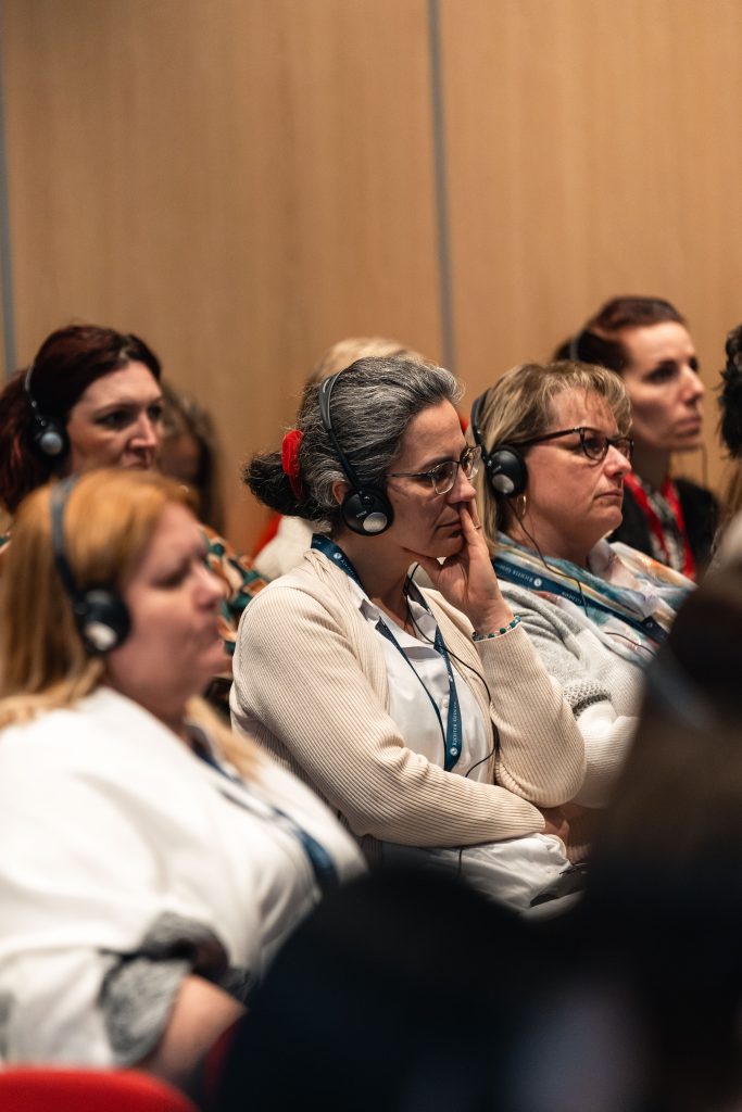A konferencia közönsége ülve követi a programot.
